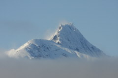 45 die verschneiten Berggipfel ragen aus den Wolken