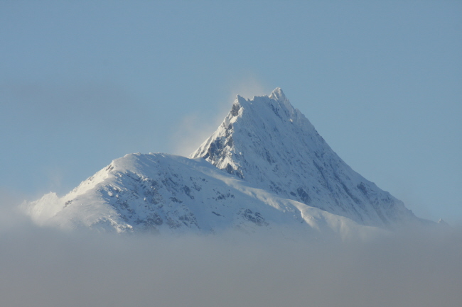 45 die verschneiten Berggipfel ragen aus den Wolken